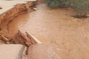 صورة تظهر انهيارًا وانجرافًا في جزء من طريق معبد نتيجة السيول، فيما تتدفق مياه موحلة بقوة عبر مجرى مائي في إحدى مناطق الجنوب الليبي المتضررة من الفيضانات.