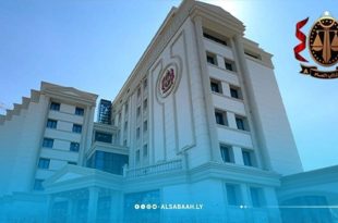 مبنى مكتب النائب العام مضاءً بالكامل ليلاً ويظهر في الزاوية العلوية اليمنى الشعار الرسمي للنيابة العامة.