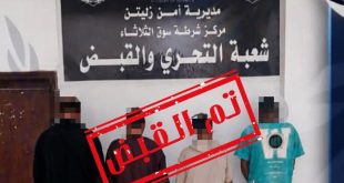 أربعة متهمين مغطى وجوههم يقفون أمام لافتة "مديرية أمن زليتن - مركز شرطة سوق الثلاثاء - شعبة التحري والقبض"،