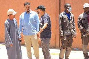 أعضاء من المجلس البلدي سبها يقفون في موقع ميداني مع عمال ومواطنين لمتابعة أعمال صيانة غرف الصرف الصحي.