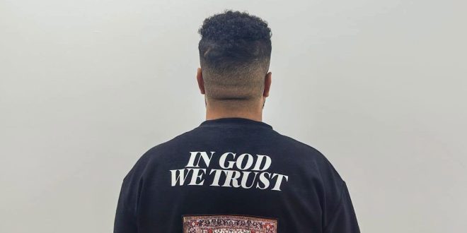 لقطة من الخلف للمتهم المقبوض عليه في حادثة سرقة رجل مسن أمام المستشفى، يرتدي قميصاً أسود