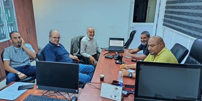 ​5 موظفين يجلسون حول طاولة اجتماعات خشبية أثناء حضورهم ورشة عمل حول الأمن السيبراني بالهيئة العامة للصحافة