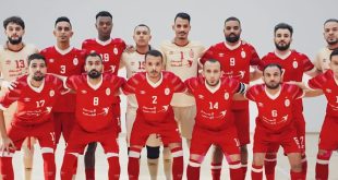 ​لقطة جماعية للاعبي فريق الاتحاد الليبي لكرة القدم داخل الصالات، يظهر فيها اللاعبون في صفين وهم يرتدون الطاقم الأساسي باللونين الأحمر والأبيض ويقفون بوضعية الاستعداد لالتقاط الصورة الرسمية