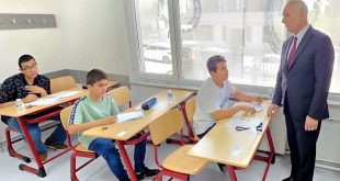تلاميذ ليبيون يؤدون الامتحانات داخل فصل دراسي بوجود مشرف يتابع سير العملية الامتحانية بالخارج.