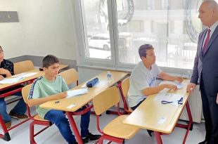 تلاميذ ليبيون يؤدون الامتحانات داخل فصل دراسي بوجود مشرف يتابع سير العملية الامتحانية بالخارج.