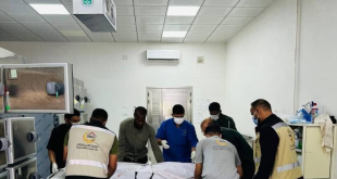 عناصر مركز طب الطوارئ والدعم في ليبيا أثناء نقل جثمان على محفة داخل ثلاجة الموتى.