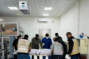 عناصر مركز طب الطوارئ والدعم في ليبيا أثناء نقل جثمان على محفة داخل ثلاجة الموتى.