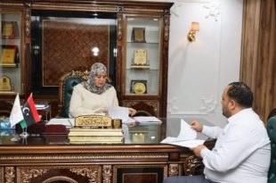 وزيرة الشؤون الاجتماعية وفاء الكيلاني تجلس في مكتبها وتراجع أوراقاً رسمية خلال اجتماع مع مدير إدارة منحة الزوجة والأولاد.