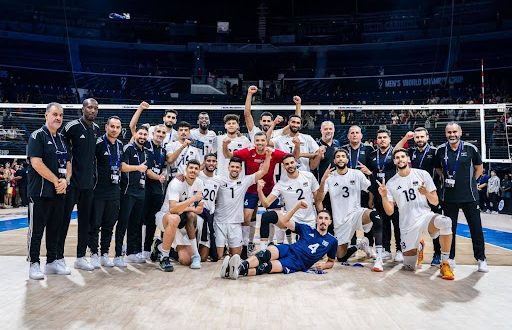لاعبو وأعضاء الجهاز الفني للمنتخب الليبي الأول للكرة الطائرة يلتقطون صورة جماعية داخل صالة المنافسات خلال مشاركتهم في بطولة دولية، قبل إعلان الاتحاد الليبي تعذر المشاركة في التصفيات الإفريقية المؤهلة لكأس الأمم الإفريقية.