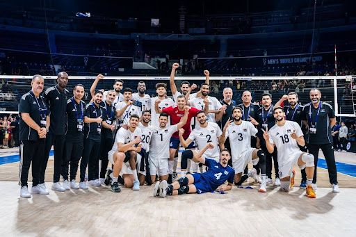 لاعبو وأعضاء الجهاز الفني للمنتخب الليبي الأول للكرة الطائرة يلتقطون صورة جماعية داخل صالة المنافسات خلال مشاركتهم في بطولة دولية، قبل إعلان الاتحاد الليبي تعذر المشاركة في التصفيات الإفريقية المؤهلة لكأس الأمم الإفريقية.