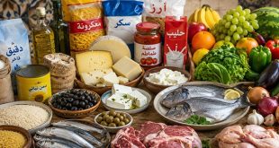 مجموعة متنوعة من المواد الغذائية تشمل اللحوم والأسماك والأجبان والخضروات والفواكه والحبوب مرتبة على طاولة، تعكس مكونات سلة الغذاء الشائعة لدى الأسر الليبية. صورة بالذكاء الاصطناعي