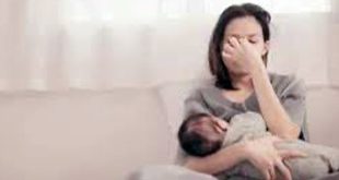 امرأة تجلس بمفردها على سرير وتبدو عليها ملامح الحزن والقلق الشديد تجسيد مرئي للمعاناة النفسية وصعوبات ما بعد الولادة.