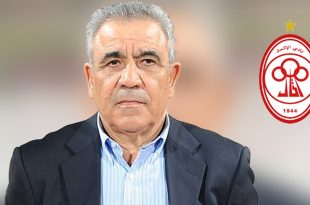 صورة بورتريه للمدرب التونسي فوزي البنزرتي ببدلة رسمية، بجوار شعار نادي الاتحاد الليبي الأ doاحمر والأبيض.