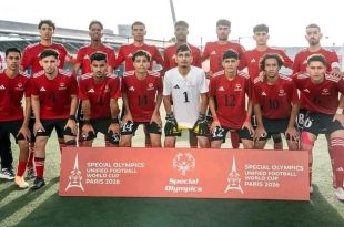 صورة جماعية لمنتخب الأولمبياد الخاص الليبي لكرة القدم الموحدة بملابسهم الرياضية الحمراء والبيضاء، يقفون خلف لوحة إعلانية حمراء تحمل شعار البطولة وكتابة باللغة الإنجليزية