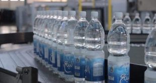 لقطة قريبة لخط إنتاج مياه "النبع" في قصر بن غشير، تظهر زجاجات مياه بلاستيكية معبأة تحمل الشعار