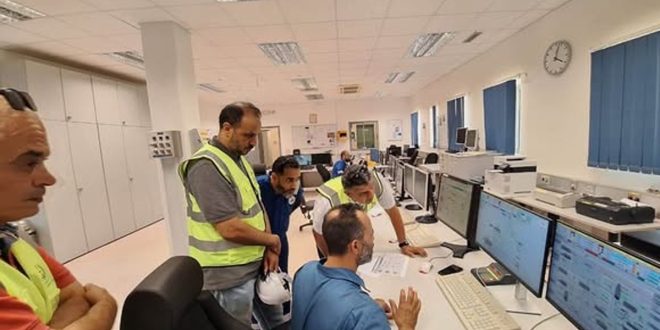 لقطة واسعة من داخل موقع نفطي صحراوي تظهر مجموعة من المهندسين والمسؤولين الفنيين التابعين للمؤسسة الوطنية للنفط