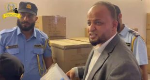 مسؤول ورجال من الحرس البلدي يتفقدون صناديق أدوية ومستلزمات طبية داخل مخزن في مستشفى الهضبة الخضراء بطرابلس.