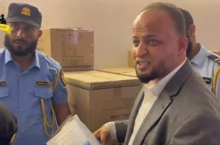 مسؤول ورجال من الحرس البلدي يتفقدون صناديق أدوية ومستلزمات طبية داخل مخزن في مستشفى الهضبة الخضراء بطرابلس.
