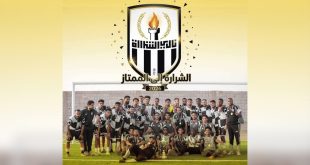 صورة جماعية للاعبي وطاقم نادي الشرارة الرياضي يرتدون الزي الأبيض والأسود ويحتفلون بكأس تصفيات المنطقة الجنوبية، ويعلوهم شعار النادي وعبارة "الشرارة إلى الممتاز 2026".