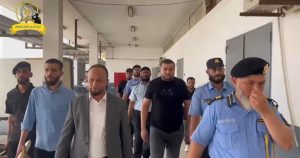 مجموعة من رجال الحرس البلدي وممثلي النيابة العامة والتحري يمشون في ممر داخل مستشفى الهضبة الخضراء العام بطرابلس أثناء جولة تفتيشية.
