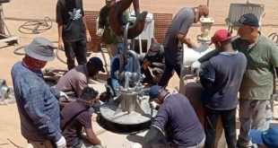 فنيو وعمال جهاز مشروع النهر الصناعي يعملون على تركيب وتجهيز مضخة مياه جديدة في أحد حقول الآبار