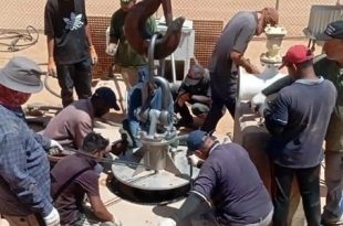فنيو وعمال جهاز مشروع النهر الصناعي يعملون على تركيب وتجهيز مضخة مياه جديدة في أحد حقول الآبار