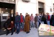 صورة مدمجة تُظهر ازدحام وطوابير مواطنين أمام جهاز سحب آلي (ATM) لمصرف تجاري، وفي أسفل اليمين حزمة أوراق نقدية ليبية من فئة العشرين ديناراً.