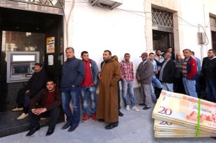 صورة مدمجة تُظهر ازدحام وطوابير مواطنين أمام جهاز سحب آلي (ATM) لمصرف تجاري، وفي أسفل اليمين حزمة أوراق نقدية ليبية من فئة العشرين ديناراً.