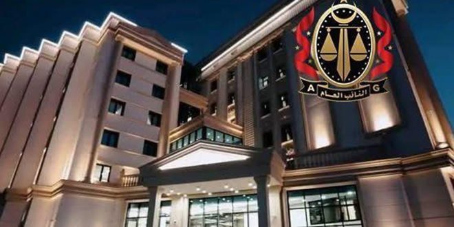 مبنى النيابة العامة الفاخر والمضاء بأنوار بيضاء، ويظهر في أعلى زاوية اليمين شعار مكتب النائب العام الليبي المتميز باللونين الأسود والذهبي مع لمسات حمراء ترمز للعدالة والميزان
