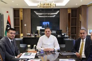 ​رئيس حكومة الوحدة الوطنية عبد الحميد الدبيبة يترأس اجتماعاً مع مسؤولين لمناقشة تعديلات مخصصات الإسكان الشبابي، ويظهر العلم الليبي في خلفية المكتب