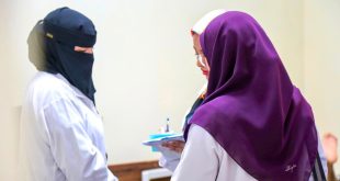 ثلاث طبيبات أو أخصائيات يرتدين معاطف طبية بيضاء يتشاورن معاً ويمسكن بملف طبي، أثناء زيارة طبية لمركز الأندلس لتأهيل وعلاج ذوي الإعاقة.