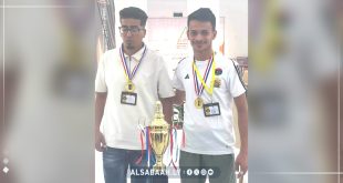 شابان يحملان ميداليات ذهبية ويتوسطهما كؤوس البطولة في فعاليات بطولة الشطرنج للجامعات الليبية بجامعة غريان.