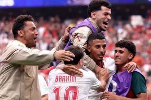 ​فرحة عارمة للاعبي المنتخب المغربي لكرة القدم، يظهر فيها اللاعب إبراهيم دياز بقميصه رقم 10 محتضناً زملاءه عز الدين أوناحي وسفيان رحيمي وبقية عناصر المنتخب أثناء الاحتفال بتأهلهم التاريخي في كأس العالم