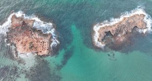 صورة جوية تُظهر جزيرتي معطن العقلة قبالة الساحل الليبي، حيث تبدو بقايا أثرية محفورة في الصخور، ويُعتقد أن الموقع قد يرتبط بمدينة كاينوبولس المفقودة.