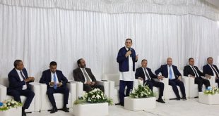 ​رئيس حكومة الوحدة الوطنية عبد الحميد الدبيبة يلقي كلمة واقفاً وممسكاً بمذياع، خلال اجتماعه مع أعيان وحكماء بلدية زليتن بحضور عدد من الوزراء والمسؤولين الجالسين على مقاعد بيضاء خلف خلفية من الستائر البيضاء