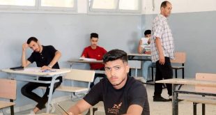 طلاب يؤدون امتحان الدور الثاني للشهادة الثانوية داخل قاعة امتحان، بينما يشرف أحد المراقبين على سير الامتحانات.