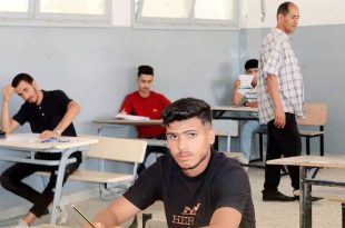 طلاب يؤدون امتحان الدور الثاني للشهادة الثانوية داخل قاعة امتحان، بينما يشرف أحد المراقبين على سير الامتحانات.