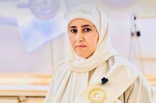 لعميدة بلدية زلطن الزائرة المقطوف وهي ترتدي حجاباً ورداءً تقليدياً أبيض، ويظهر على الكتف وشاح يحمل شعاراً رسمياً.