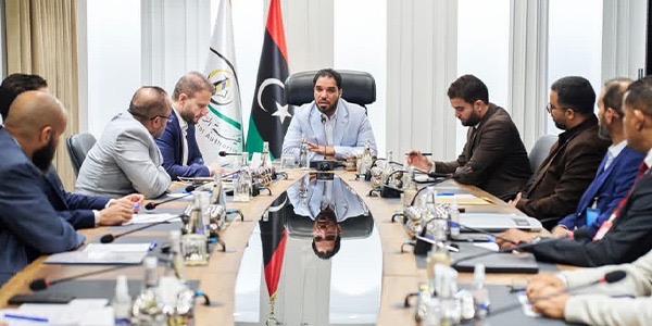 يس هيئة الرقابة الإدارية عبد الله قادربوه يترأس اجتماعاً حول طاولة اجتماعات بيضاوية طوالية تضم عدداً من أعضاء ورؤساء اللجان الرقابية، وخلفه العلم الليبي وشعار هيئة الرقابة الإدارية.