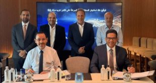 صورة لمراسم توقيع اتفاقية بين مسئولين من شركة ليبيا للاتصالات والتقنية "LTT" والمنظمة العربية للاتصالات الفضائية "عرب سات"، حيث يجلس شخصان على طاولة توقيع العقود وأمامهما المستندات، وخلفهما أربعة من المسئولين يقفون أمام شاشة عرض مكتوب عليها "توقيع عقد استئجار السعات... على القمر عرب سات 6A".