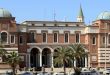 المبنى الرئيسي التاريخي لمصرف ليبيا المركزي في طرابلس، بتصميمه المعماري المميز ذي القباب والأقواس والأحجار الطوبية، وأمامه أشجار النخيل وعدد من السيارات المتوقفة