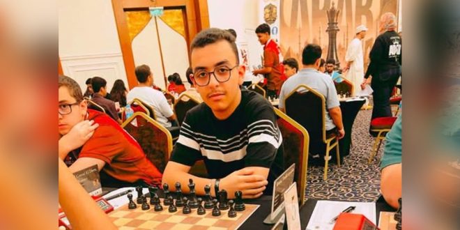 لاعب المنتخب الوطني للشطرنج توفيق الكويري يرتدي نظارة ويجلس أمام رقعة الشطرنج خلال مشاركته في البطولة العربية للشطرنج الخاطف تحت 16 عاماً بالقاهرة.