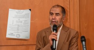 صورة لأخصائي المبيدات سالم الشبلي يتحدث عبر الميكروفون وإلى جانبه وثيقة قرار وزارة الزراعة بشأن المبيدات.