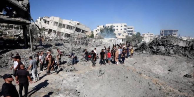 لقطة واسعة لدمار واسع النطاق في قطاع غزة، حيث تحولت المباني إلى ركام وأنقاض، ويظهر مدنيون فلسطينيون يسيرون بين الحطام وسط مشهد من الخراب. هذا الدمار هو موضوع إدانة مشتركة من قبل ثماني دول عربية وإسلامية طالبت بوقف الحرب