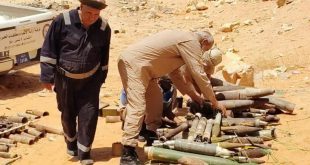 ​عناصر من هيئة السلامة الوطنية يعاينون كمية من مخلفات الحرب والذخائر غير المنفجرة في منطقة صحراوية بمدينة بني وليد تمهيداً لإتلافها.
