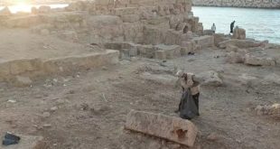 ​شخص يجمع المخلفات في أكياس سوداء بين الآثار الحجرية المطلة على البحر بمدينة سوسة ضمن مشروع تنظيف الآثار.