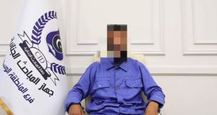 ​صورة شخص متهم بوقائع نصب تم طمس وجهه، يججلس بجوار علم جهاز المباحث الجنائية (المنطقة الوسطى