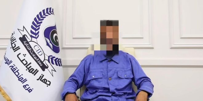 ​صورة شخص متهم بوقائع نصب تم طمس وجهه، يججلس بجوار علم جهاز المباحث الجنائية (المنطقة الوسطى