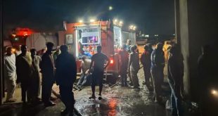 ​صورة ليلية لسيارة إطفاء وتجمهر لرجال الإطفاء والمواطنين أمام مخزن مواد الغذائية بعد السيطرة على حريق في طبرق.