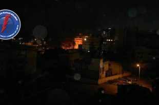 ​صورة ليلية لمنطقة سكنية مظلمة مع شعار الشركة العامة للكهرباء، تعبيرًا عن آلاف بلاغات الأعطال وانقطاع التيار.